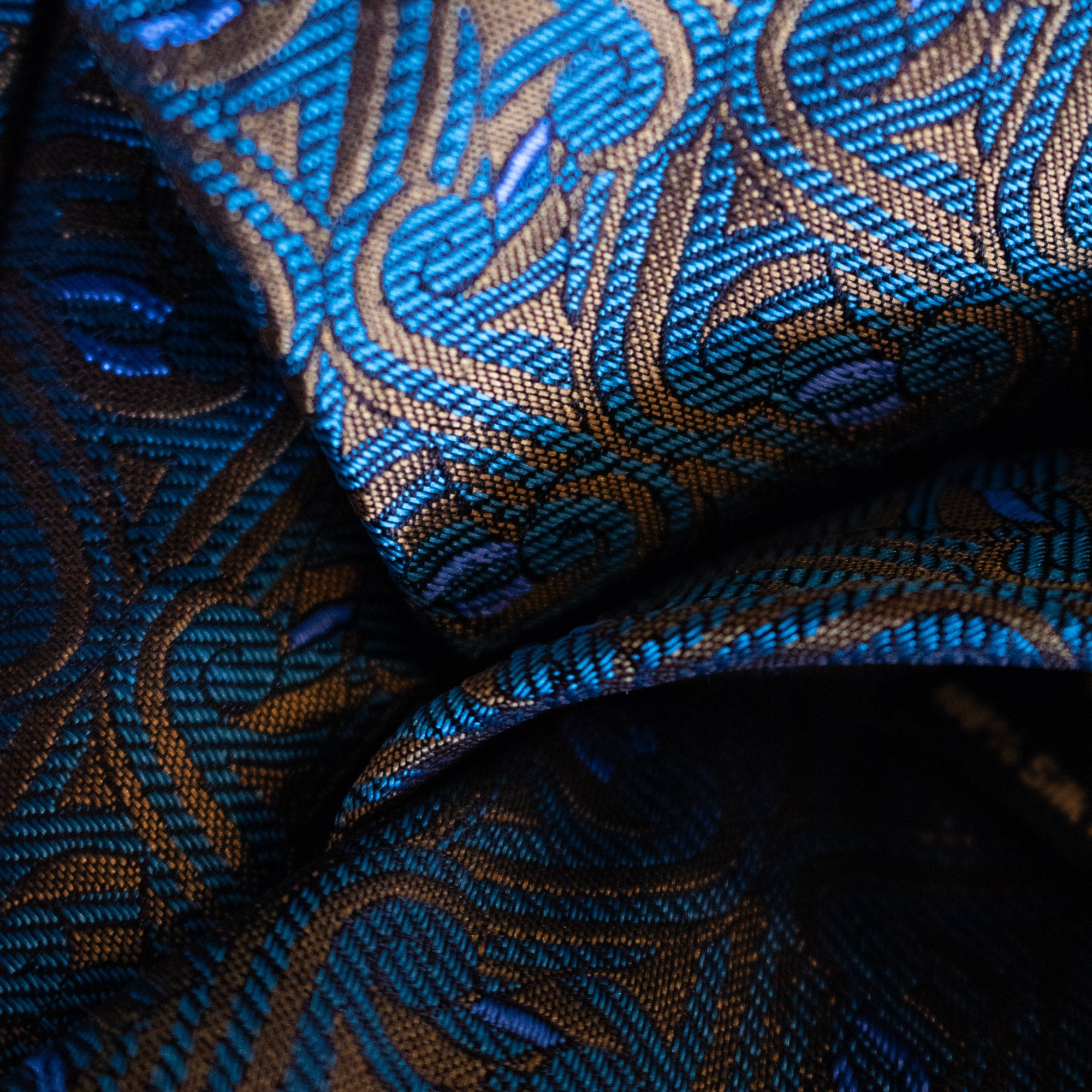 Close-up of jacquard-woven silk fabric in gold, teal and blue