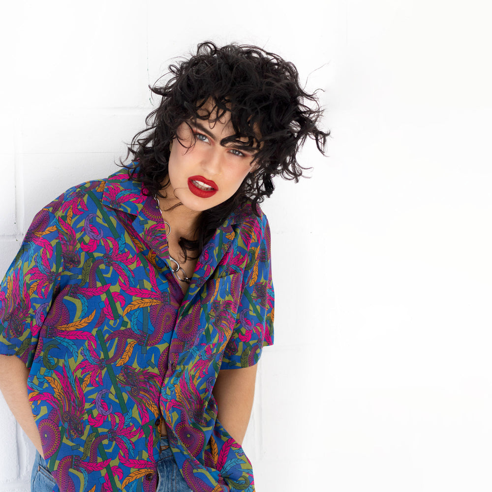Person wearing a colorful patterned shirt against a white background