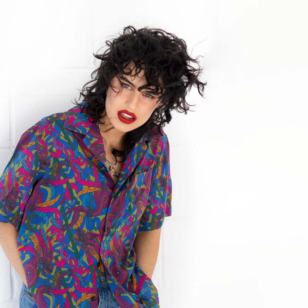 Person wearing a colorful patterned shirt against a white background