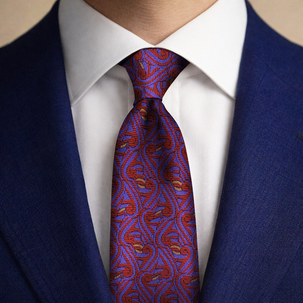 Blue, red and gold tie featuring the Thames Pattern worn with a blue suit