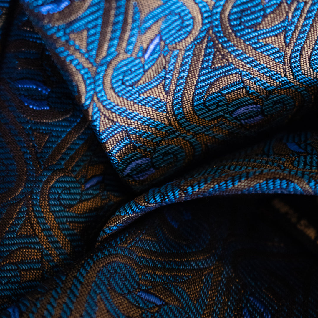 Close-up of jacquard-woven silk fabric in gold, teal and blue